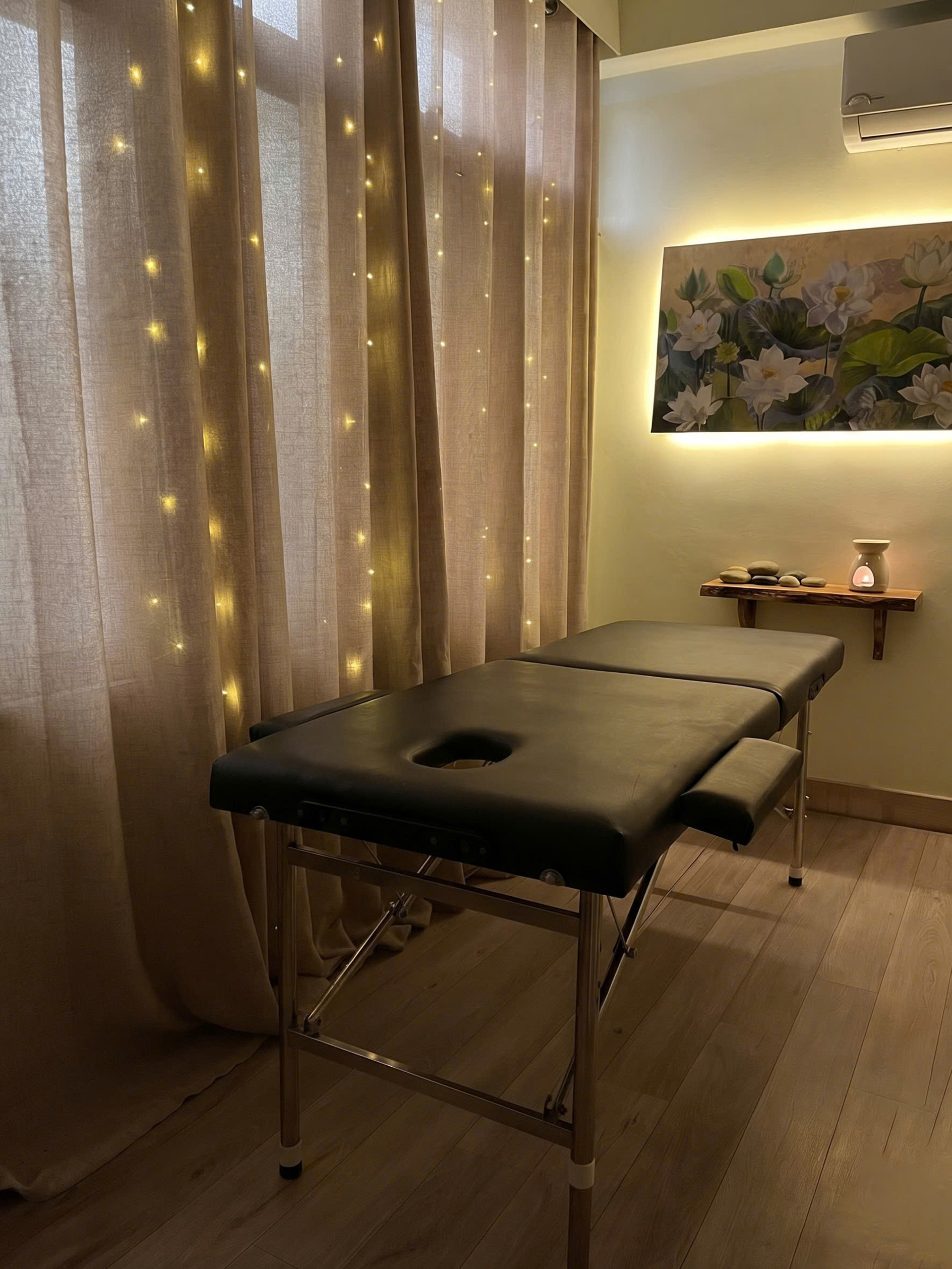 Không gian nến thơm ấm cúng và tranh hoa sen tại Massage Yoni Chùa Bộc