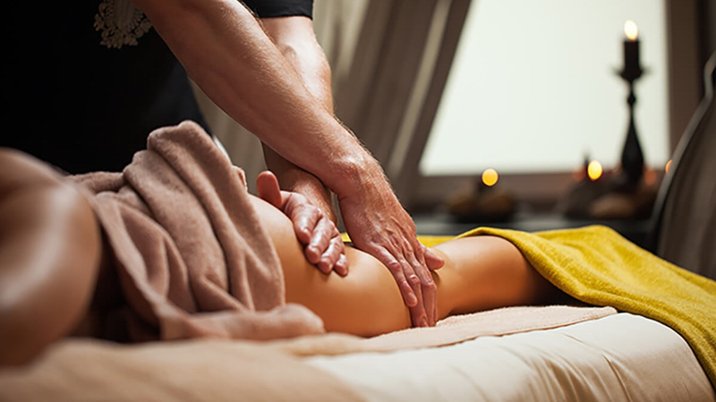 Kỹ thuật viên nữ đeo găng tay y tế sạch chuẩn bị massage trị liệu
