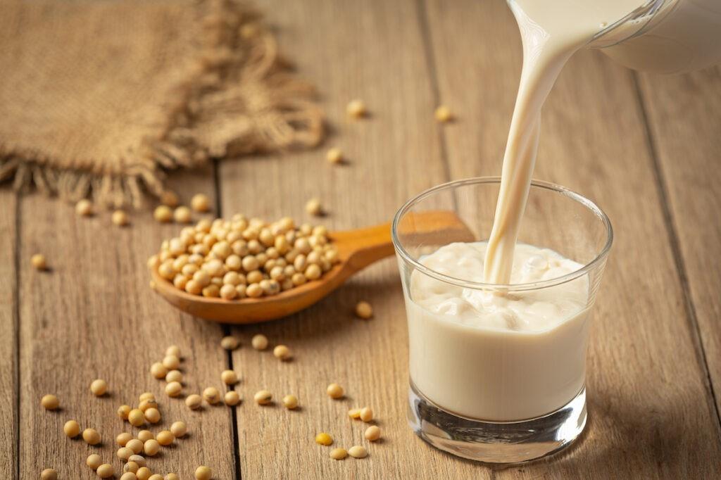 Một người phụ nữ tuổi 30 đang lựa chọn thực phẩm lành mạnh gồm đậu phụ, sữa đậu nành và các loại hạt để chăm sóc vùng kín từ bên trong