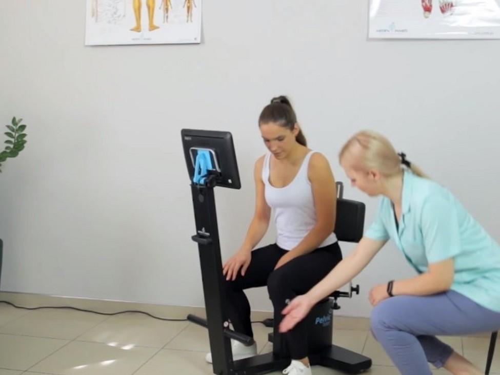 Kỹ thuật viên hướng dẫn sản phụ bài tập phục hồi cơ sàn chậu và massage vùng bụng dưới sau sinh
