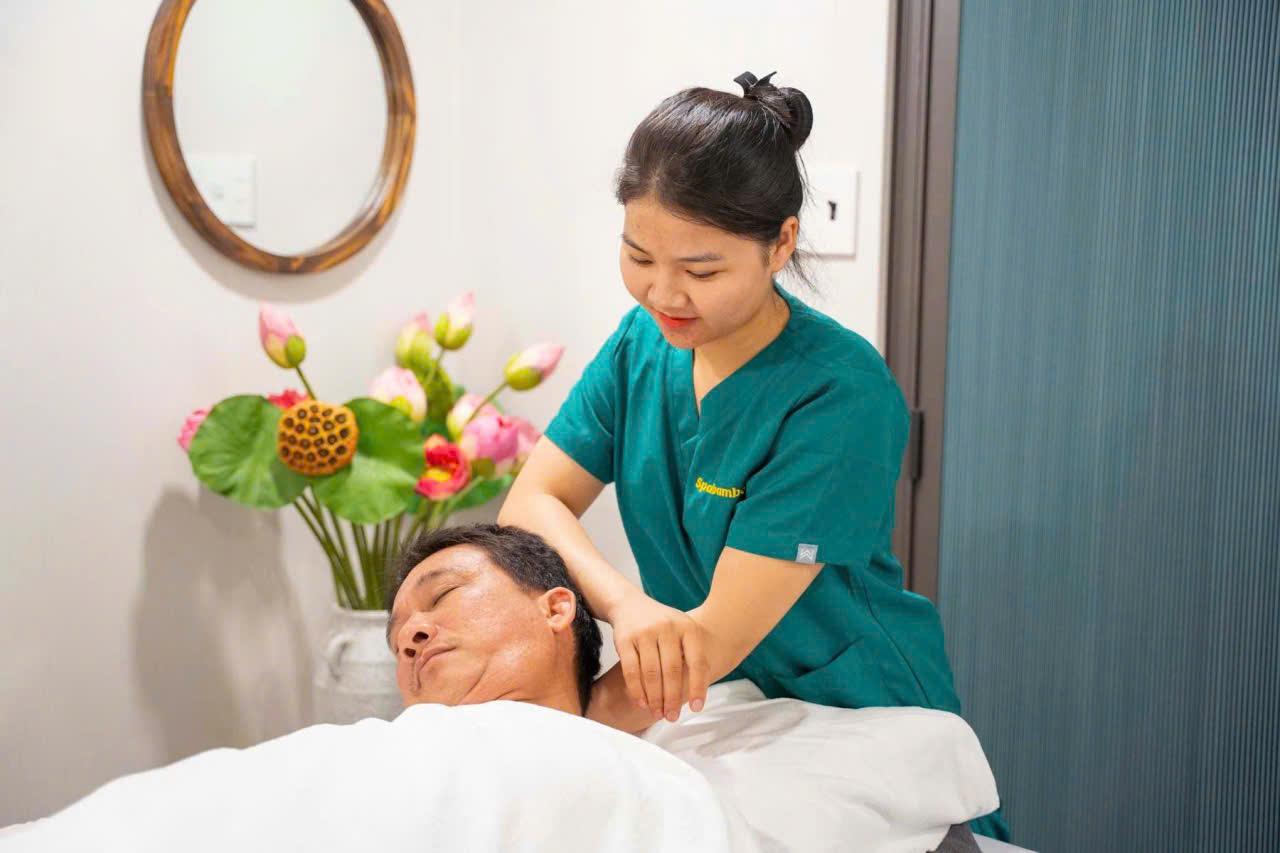 Nhân viên văn phòng làm việc đêm thư giãn với tách trà ấm sau buổi massage yoni, tận hưởng cảm giác nhẹ nhàng, hết mỏi vai
