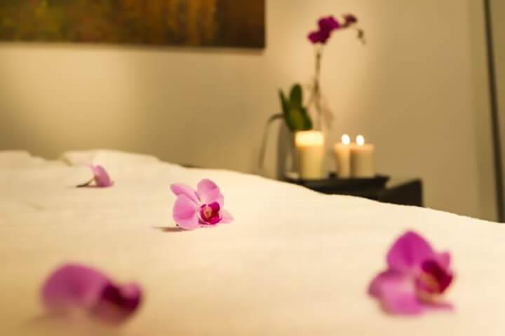 Không gian massage yoni sang trọng, riêng tư với nến thơm và hoa tươi tạo cảm giác thư giãn tuyệt đối.