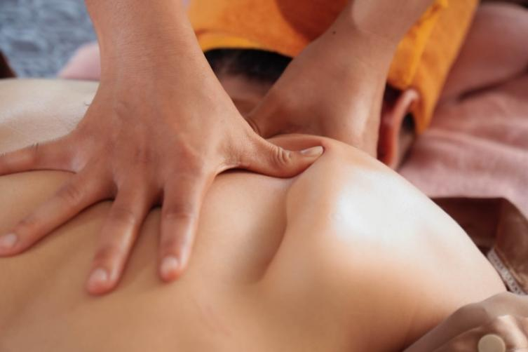 Kỹ thuật viên thực hiện động tác massage mô sâu vùng lưng kết hợp lắng nghe tâm sự