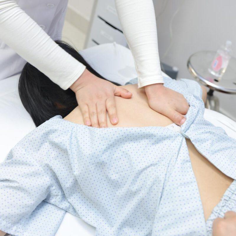 Kỹ thuật viên thực hiện xoa bóp vùng bụng trong liệu trình se khít vùng kín sau sinh