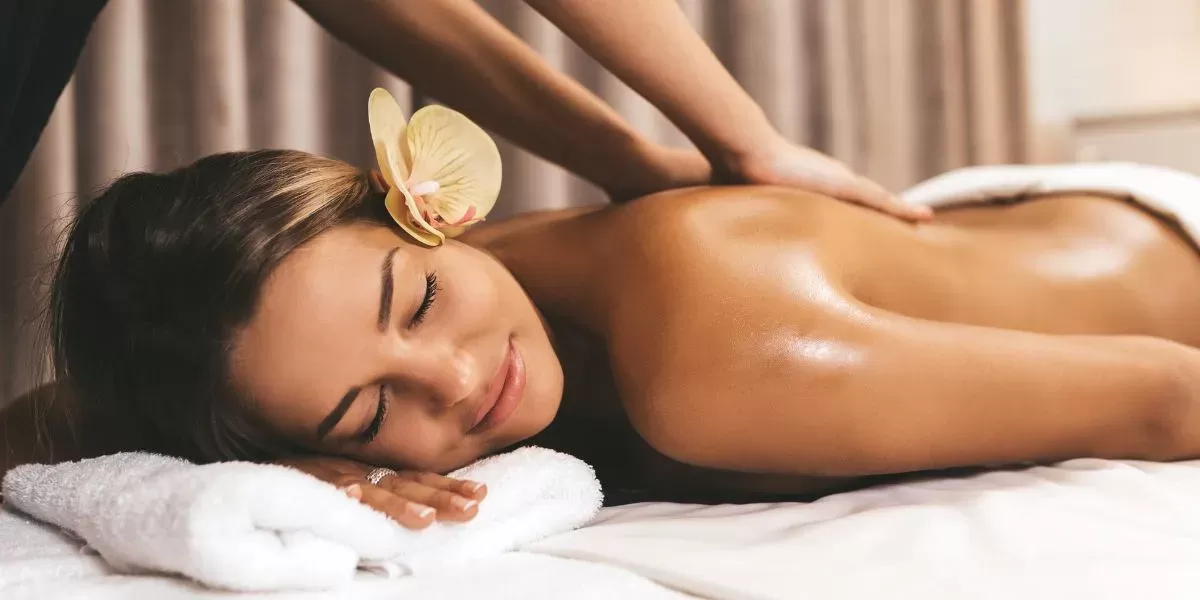 Người phụ nữ mệt mỏi sau đêm dài được thư giãn với massage tinh dầu ấm trong không gian spa tối