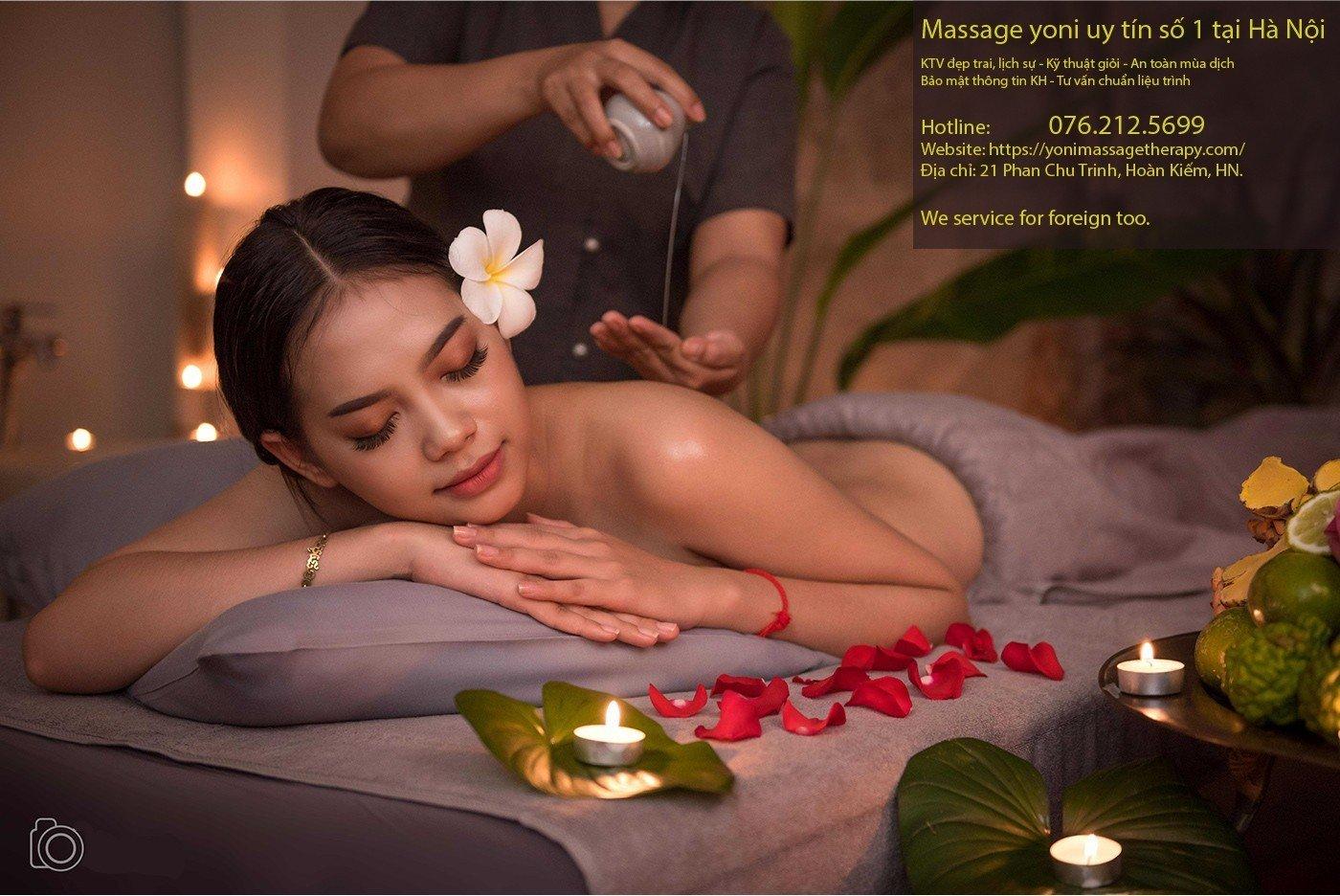 Kỹ thuật viên nữ đang thực hiện massage yoni với đá nóng và tinh dầu cho khách hàng nữ, thể hiện sự chuyên nghiệp và an toàn