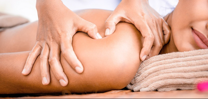Kỹ thuật viên nữ thực hiện massage bấm huyệt vùng chậu cho phụ nữ sau sinh tại phòng trị liệu ấm cúng.