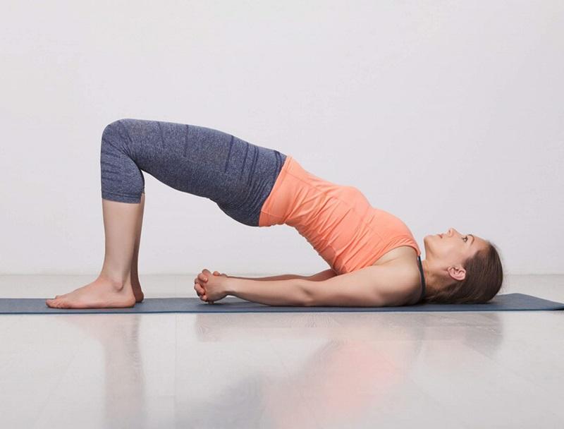 Phụ nữ tập tư thế yoga cây cầu để cải thiện cơ sàn chậu