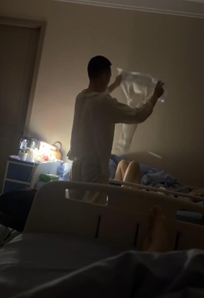Một phụ nữ đang nhẹ nhàng soi gương và đặt tay lên bụng dưới với ánh mắt yêu thương