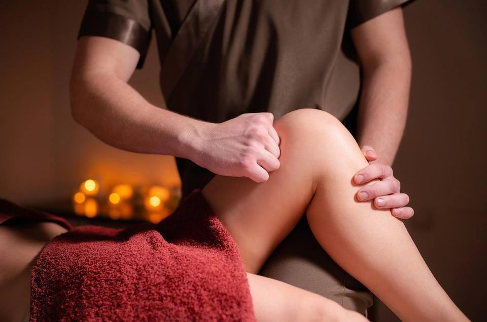 Người phụ nữ trò chuyện cùng chuyên viên trị liệu trong phòng massage ấm cúng trước khi bắt đầu liệu trình