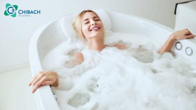 Người phụ nữ đang thư giãn và chăm sóc sức khỏe vùng kín trong phòng tắm sạch sẽ, thoải mái